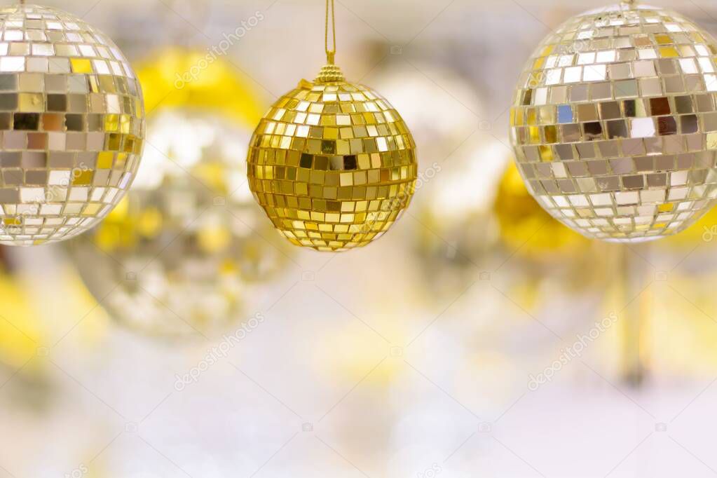 A closeup of shiny Christmas tree decorations hanging on white branches