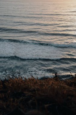 Gün batımında sahilin dikey görüntüsü.