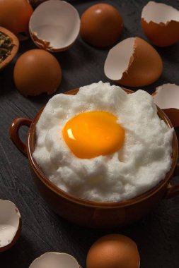 Yumurta kabuklu bir kasede taze pişmiş yumurta, masada ahşap bir kepçe.