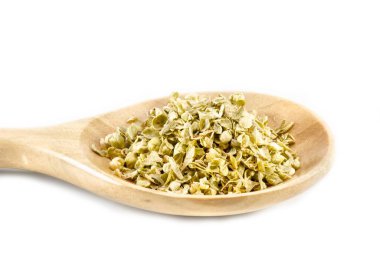 Tahta kaşığın üzerinde beyaz bir arka planda kekik otu resmi.