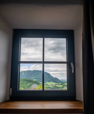 Bulutlu bir günde manzarayı gösteren kare siyah bir pencerenin güzel bir görüntüsü.