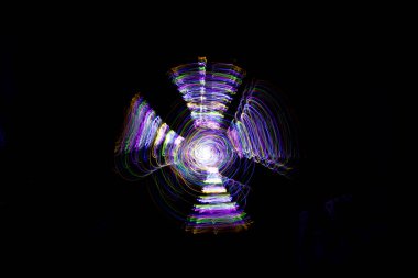 Aydınlık boya, karanlık bir göz etrafında soyut bir yörüngeyi gösteren siyah bir arkaplan oluşturur..