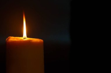 Bir mum ışığı karanlığı aydınlatır.