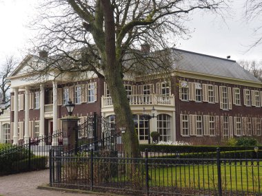 Bergen 'de metal çitlerle çevrili tuğlalardan yapılmış büyük bir villanın hava görüntüsü.