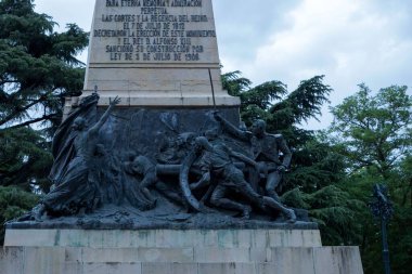 Segovia 'daki Daoiz ve Velarde anıtı. Gri gökyüzü ve arka planda ağaçlarla dikey çekim.