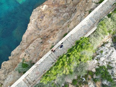 Uçurumun kıyısındaki geçitteki insanların hava manzarası.