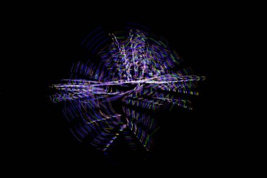 Aydınlık boya, karanlık bir göz etrafında soyut bir yörüngeyi gösteren siyah bir arkaplan oluşturur..