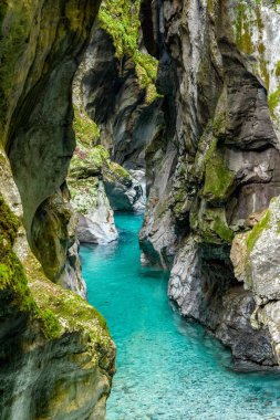 Slovenya 'daki kayalık Tolmin vadisindeki turkuaz akışının dikey nefes kesen görüntüsü