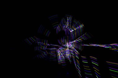 Aydınlık boya, karanlık bir göz etrafında soyut bir yörüngeyi gösteren siyah bir arkaplan oluşturur..