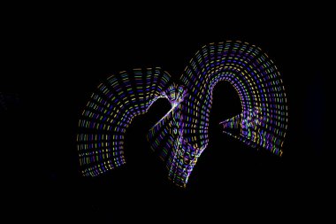 Aydınlık boya, karanlık bir göz etrafında soyut bir yörüngeyi gösteren siyah bir arkaplan oluşturur..