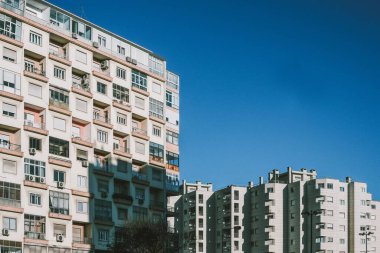 Ön cephesinde güneş ışığı, arka planında mavi gökyüzü olan güzel binalar.