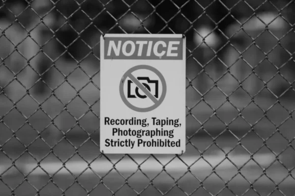 Ένα Γκρέιζ Σκέιλ Κοντά Μια Ειδοποίηση Απαγόρευσης Ένα Μεταλλικό Φράχτη — Φωτογραφία Αρχείου