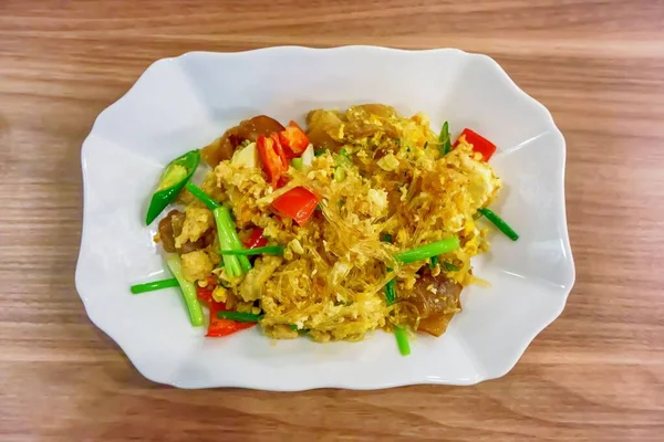 Kızarmış vermicelli 'nin beyaz tabakta servis edilen sebzeli yüksek açılı görüntüsü.