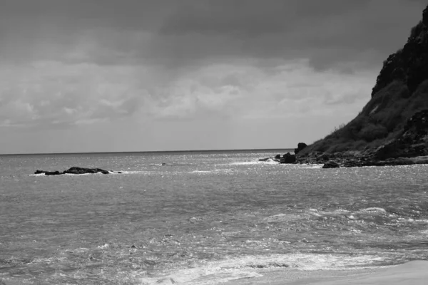 Sakin deniz ve kayaların gri tonlu görüntüsü. Oahu, Hawaii.