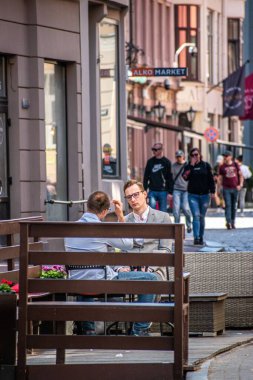 Bir kafede oturan iki adamın dikey görüntüsü. Riga, Letonya.