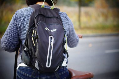 Hi-Tec marka sırt çantası ve yol kenarında bisikleti olan bir kadın.