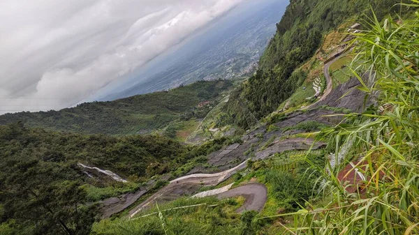 Bir dağ manzarasının önünde dolambaçlı bir patika manzarası