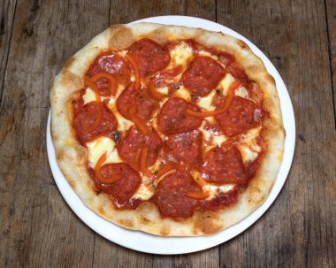 Kırmızı soslu pizza, mozzarella peyniri, pepperoni ve dolmalık biber.