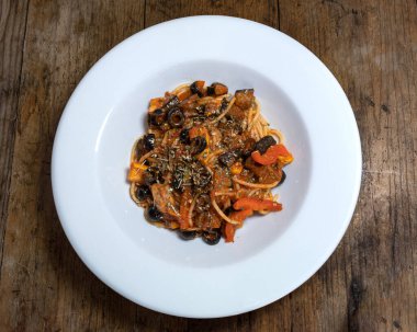 Bolonez soslu makarna, patlıcan, kabak, mantar, dolmalık biber, zeytin ve ahşap zemin üzerinde parmesan peyniri.