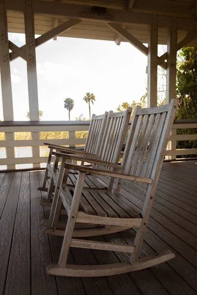 Tahta bir kulübede üç sallanan sandalyenin dikey çekimi.