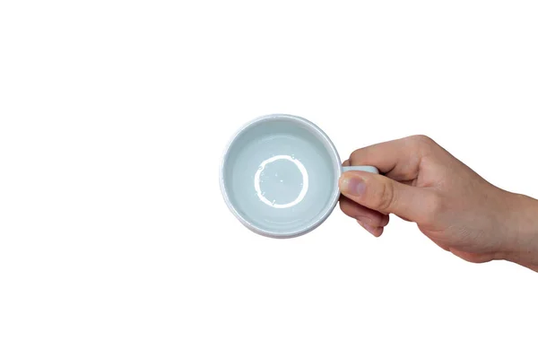 白い背景に空のセラミックカップを持つ白い手のトップビュー — ストック写真