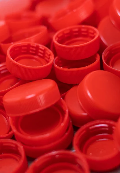 Vertical image of closeup to red plastic bottle caps