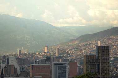 Skyline of a city during a sunset with many buildings and mountains in the background. Medellin Colombia