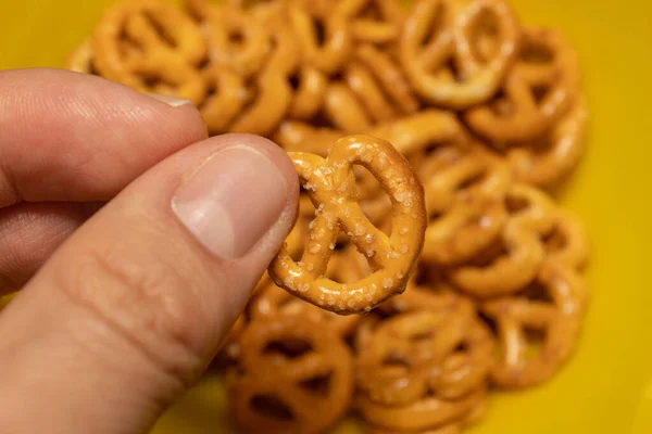 White Hand Foreground Holding Small Pretzel Group Out Focus Pretzels — Stock Photo, Image