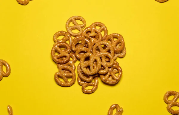 Group Small Pretzels Together Others Scattered Yellow Background — Stock Photo, Image
