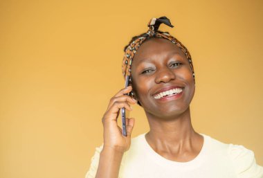 Sarı arka planda gülümseyen bir kadın.