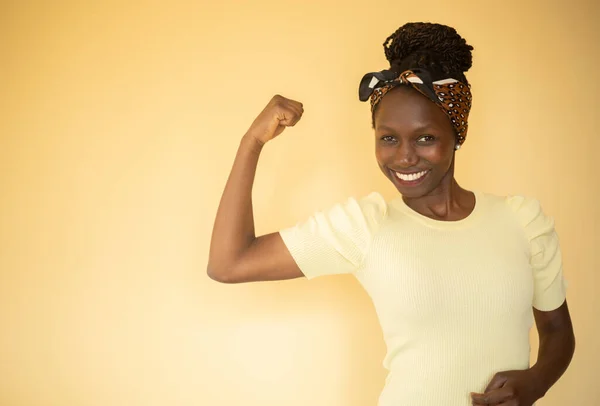 Happy young feminist woman showing her biceps
