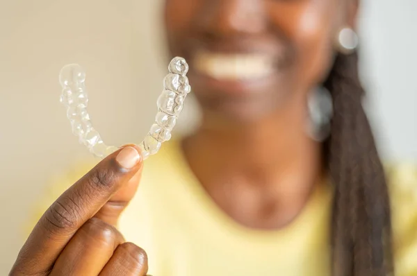 Young Woman Holding Invisible Aligner While Smiling Stock Picture