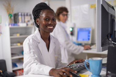 Genç tıp subayı çalışma alanının yanında gülümsüyor.