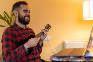 hippi adam ukulele dersleri veriyor ya da alıyor.