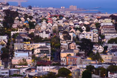 Rolling San Francisco hills with peaked roof homes and streets at golden hour