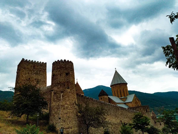 above the turquoise waters of the Zhinvali reservoir, surrounded by the picturesque forest-mountain massif of Sheupovari, Ananuri rises.