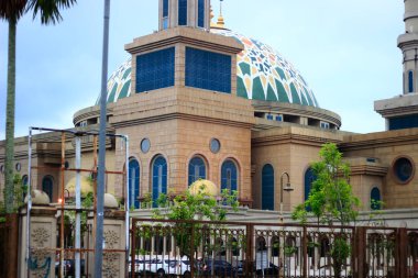Samarinda İslam Merkezi Camii 'nin çeşitli açılardan çekilmiş fotoğrafları, bir avlu ve ağaçlarla dolu bir bahçe ve açık bir gökyüzü ile birlikte..