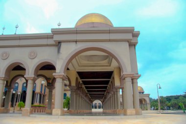 Samarinda İslam Merkezi Camii 'nin çeşitli açılardan çekilmiş fotoğrafları, bir avlu ve ağaçlarla dolu bir bahçe ve açık bir gökyüzü ile birlikte..