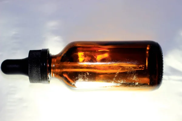 A glass bottle with a plastic cap and a small dropper to take the liquid or contents in the bottle.