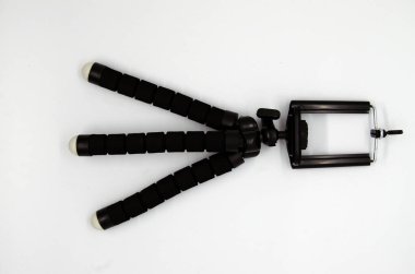 Beyaz arkaplanda tek bir akıllı telefon tripodu var.