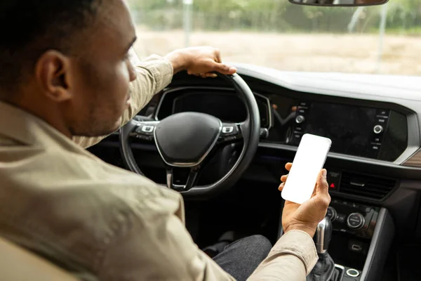 Unrecognizable Black Driver Guy Using Mobile Phone With Blank Screen Sitting In Automobile. Car Navigation App. High quality photo
