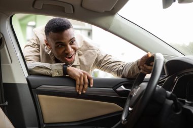 Siyah bir adam arabanın içine bakar ve çok mutlu olur. Yüksek kalite fotoğraf