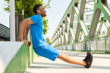 Kaslı Afrikalı Amerikalı adam spor kıyafetleriyle dışarıda egzersiz yapıyor. Yüksek kalite fotoğraf