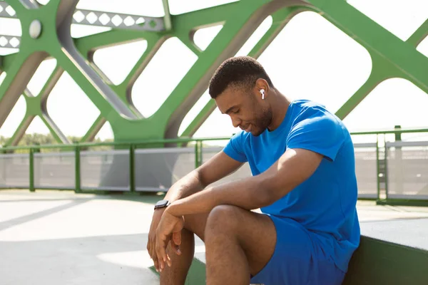 Exhausted after training or jogging sportsman sits on the street. High quality photo