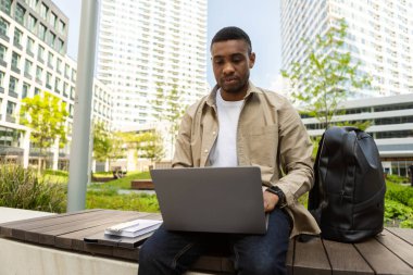 Mutlu Afro-Amerikan öğrenci şehir ortamında ödev yapıyor. Yüksek kalite fotoğraf