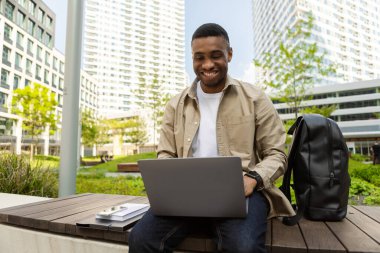 Mutlu Afro-Amerikan öğrenci şehir ortamında ödev yapıyor. Yüksek kalite fotoğraf