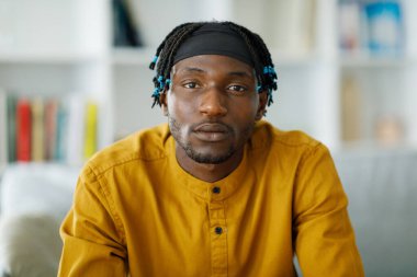 Portrait of a handsome african serious man against the backdrop of an apartment blurred background. High quality photo