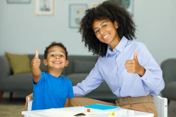 Image Young Female Teacher Showing Thumbs Her Student Sitting Classroom — Stock Photo, Image