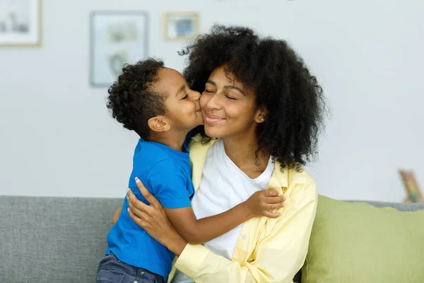 The son kisses his mother. Happy mothers day. Mother hugs her child. Shot of little boy kissing his mother at home. High quality photo