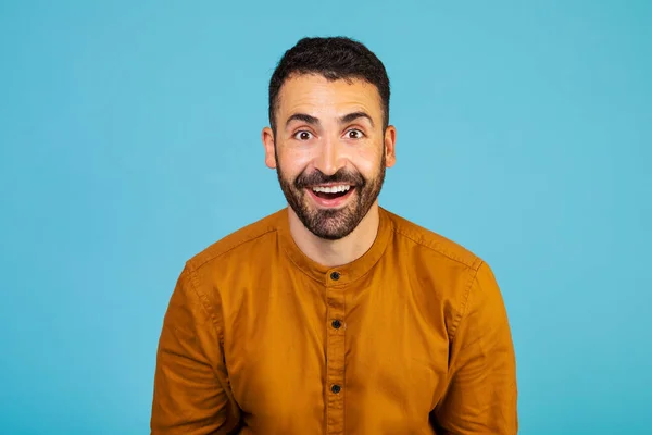 Portrait of young happy positive excited crazy shocked amazed man see big sale isolated on blue color background. High quality photo